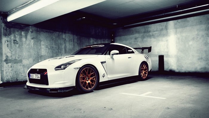 White Nissan GT-R with bronze wheels in a garage