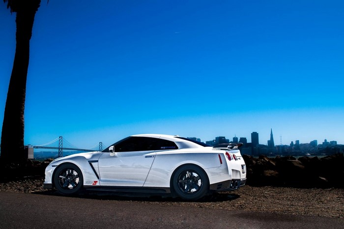 White Nissan GT-R parked with San Francisco skyline and bridge