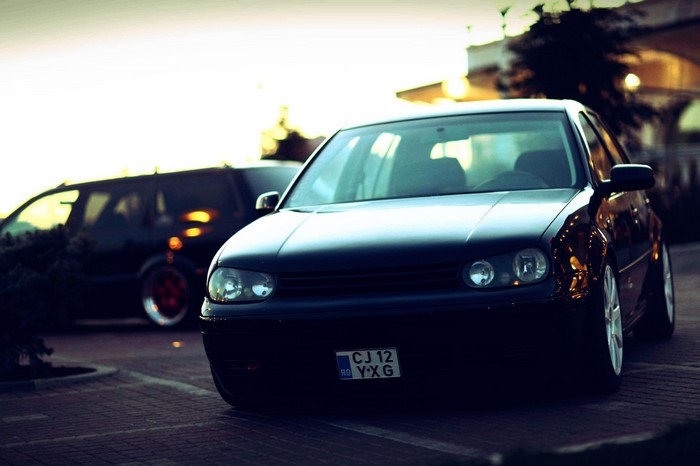 Black Volkswagen Golf IV parked on cobblestone street