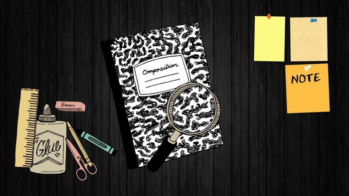 Composition notebook with school supplies on a wooden desk