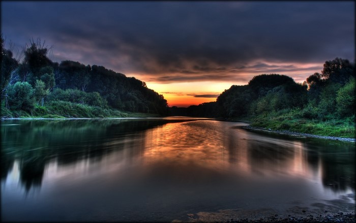 River landscape at sunset with dark clouds