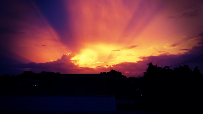 Sunset with crepuscular rays over silhouetted landscape