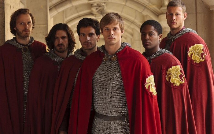 Group of knights in red cloaks with dragon emblems