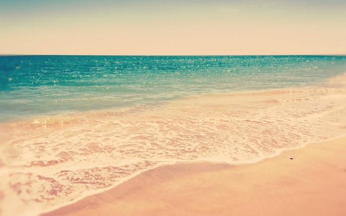 Ocean waves on a sandy beach at sunrise