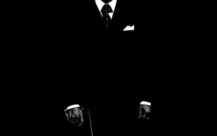Man in a black suit with a tie and pocket square