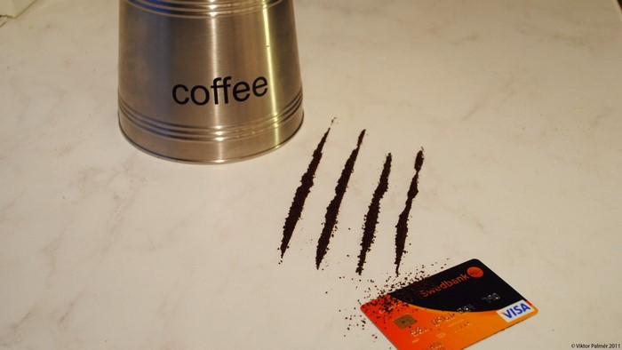 Coffee can, lines of coffee grounds, and Visa card