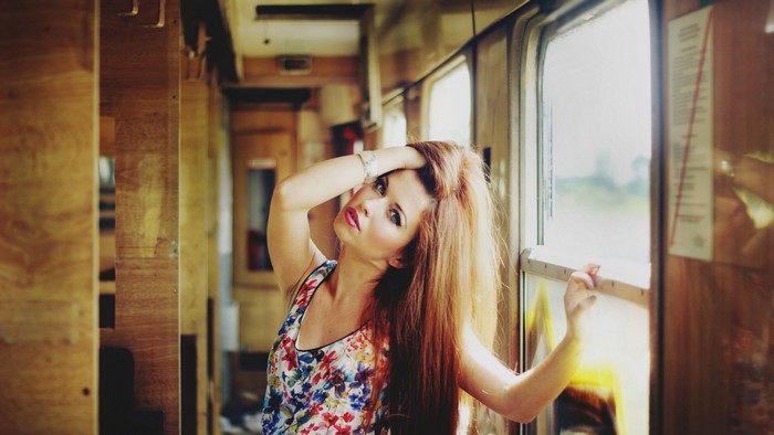 Woman with long red hair posing in a train
