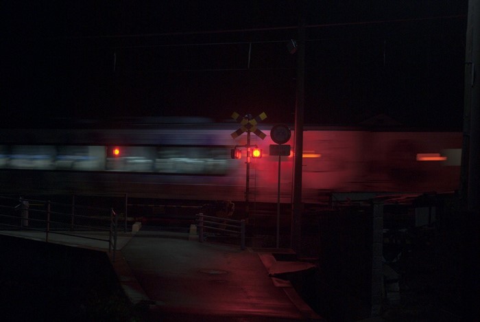 Train passing a railway crossing at night