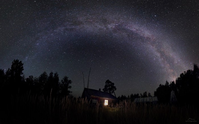 Milky Way over a rustic cabin at night