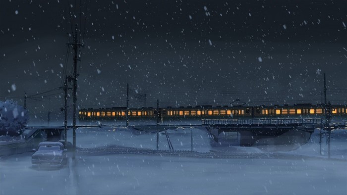 Train crossing a bridge in the snow at night