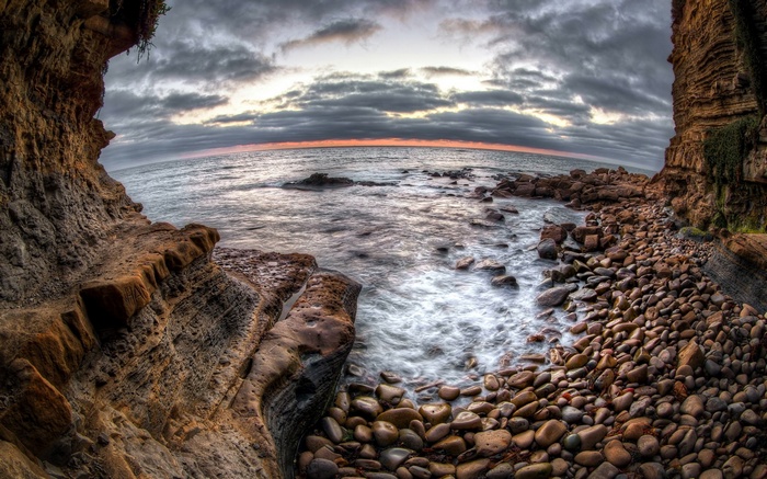 Rocky coastline with ocean waves at sunset