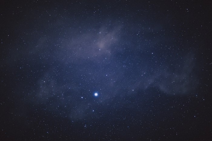 Starry night sky with nebula and bright planet