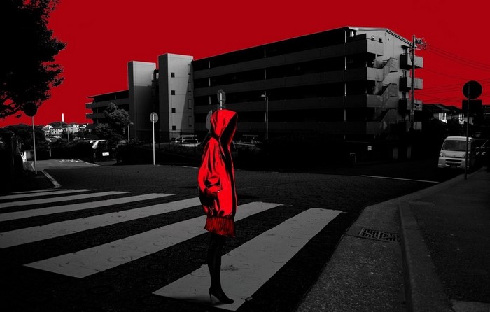 Mannequin in red dress on crosswalk with building background