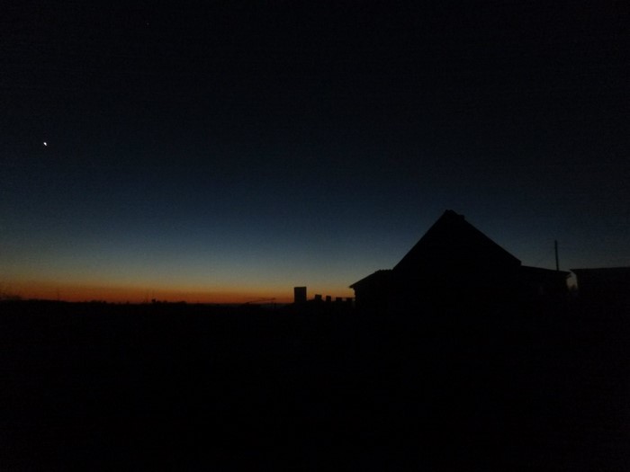 Silhouette of a house against a twilight sky with a star
