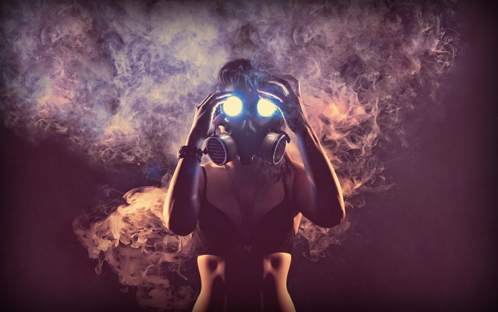 Woman in gas mask with glowing eyes and smoke