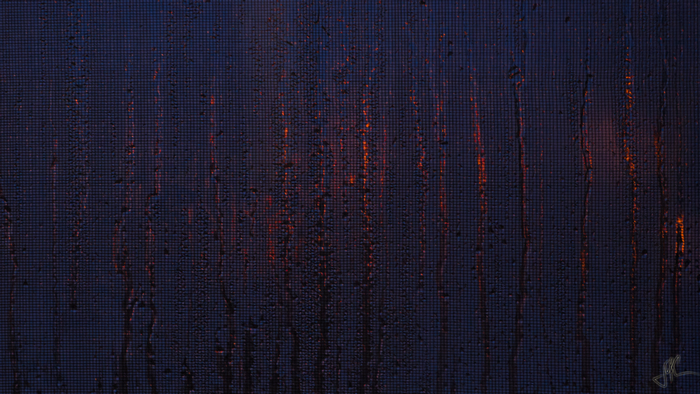 Raindrops on a window with orange light