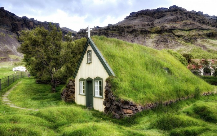 Grass-roofed church in a rural Icelandic landscape