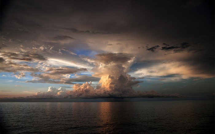 Dramatic storm clouds over the ocean at sunset