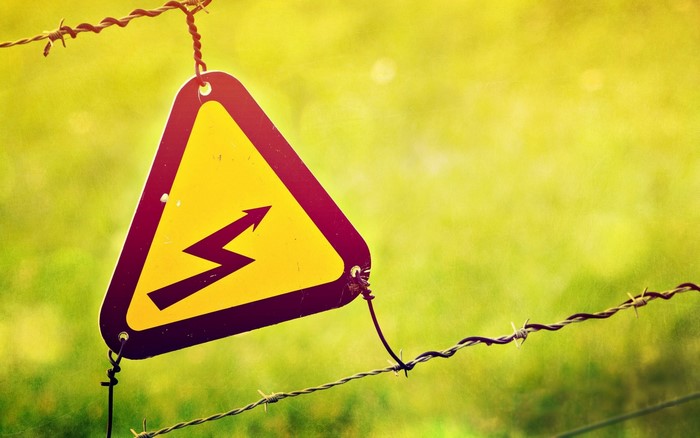 High voltage warning sign on barbed wire
