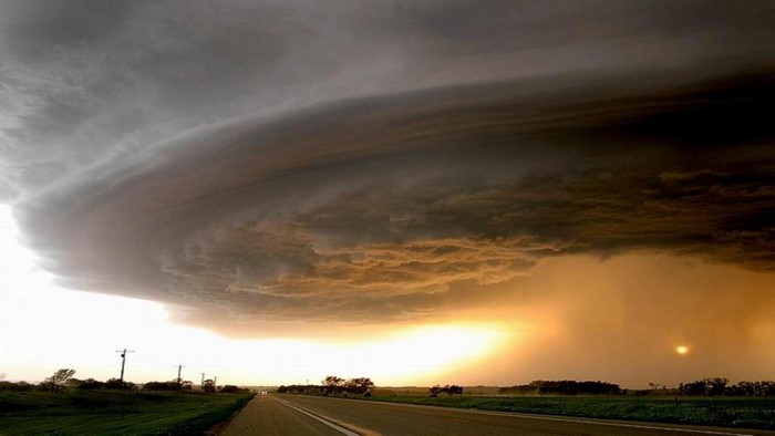 Storm clouds over a rural road at sunset