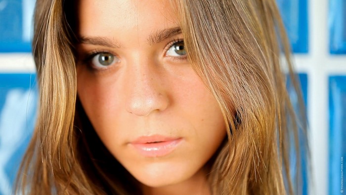 Close up portrait of a young woman with blonde hair and green eyes
