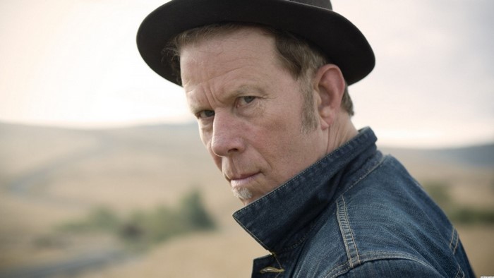 Tom Waits wearing a hat and denim jacket