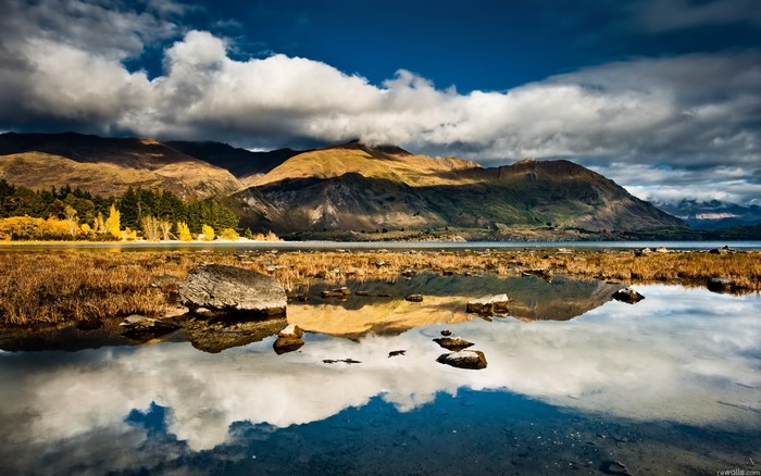 Mountain lake reflection with dramatic clouds