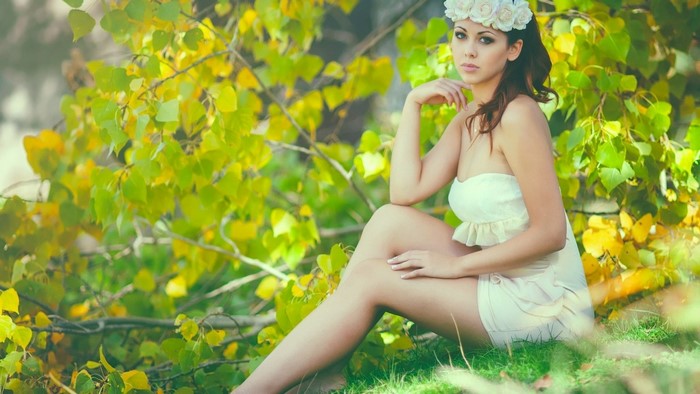 Woman with flower crown sitting in nature