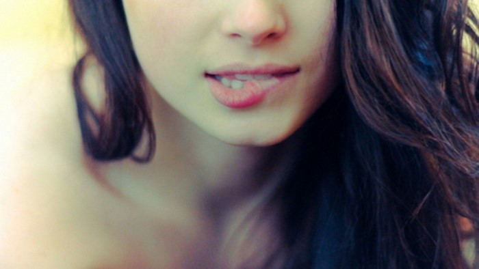 Close-up Portrait of a Young Woman Biting Her Lip