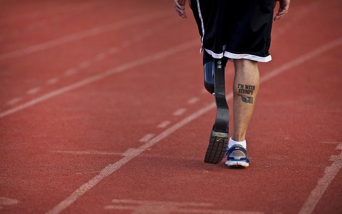 Man with prosthetic leg on running track
