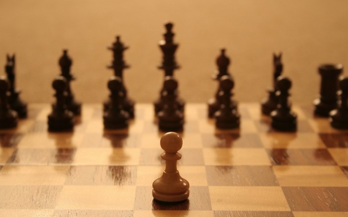 Chessboard with white pawn and black pieces
