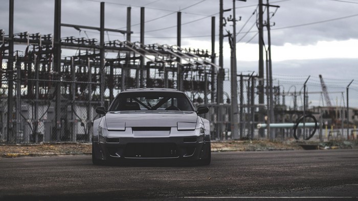 Nissan 240SX sports car in front of power station
