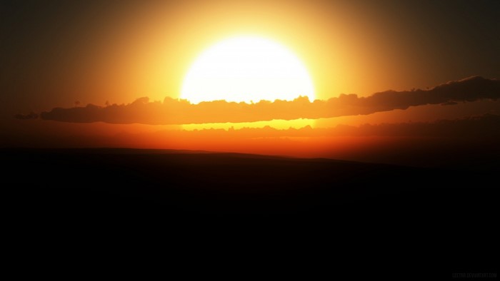 Sunset over a dark landscape with clouds