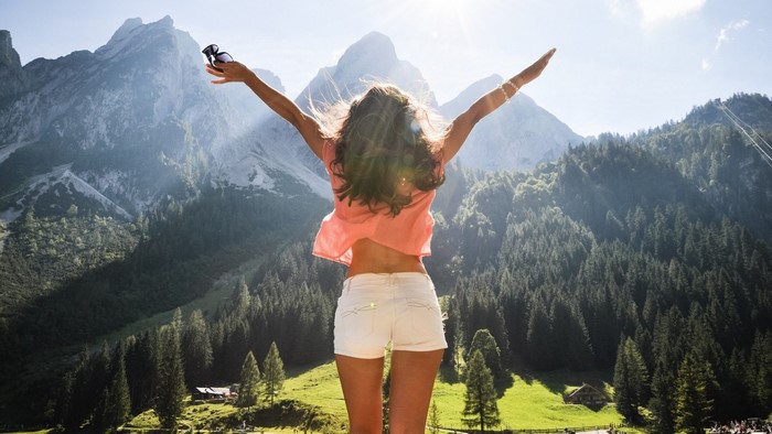 Woman with arms raised in mountains