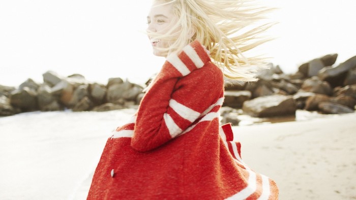 Woman in red and white striped coat on beach