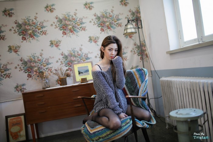 Young Woman Wearing Sweater Sitting on Chair Indoors