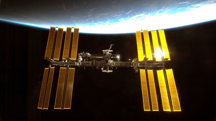 International Space Station with Earth and Sun reflection