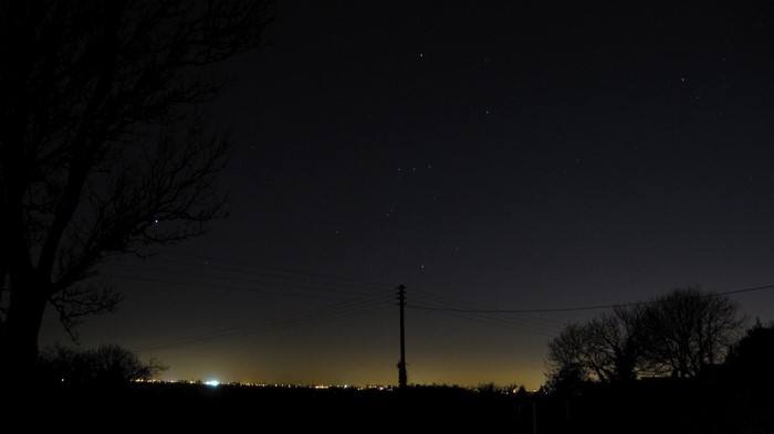 Night sky with stars over a distant town