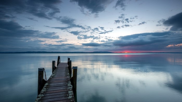 Wooden pier on a calm lake at sunset