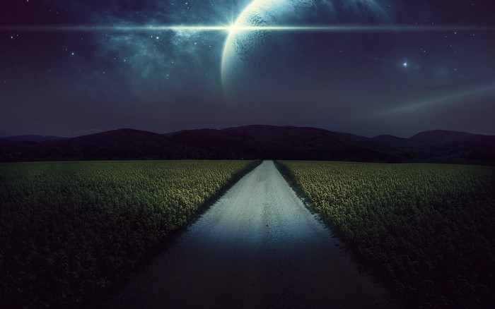 Road through a field under a starry sky with a planet