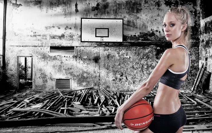Woman with basketball in abandoned gym