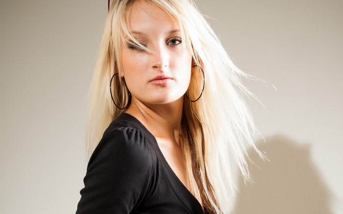 Woman with long blonde hair and hoop earrings