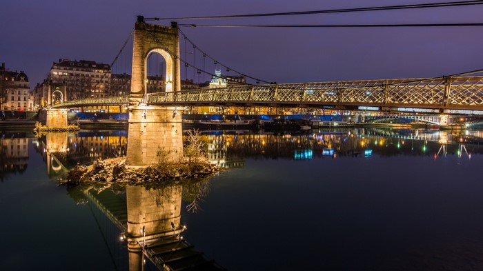 Pont Bonaparte bridge over the Saône river at night in Lyon, France