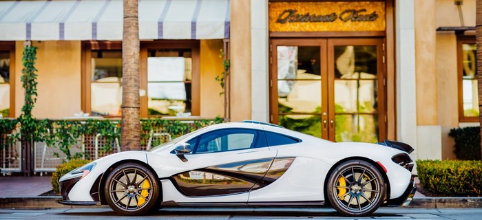 White McLaren P1 parked in front of a building