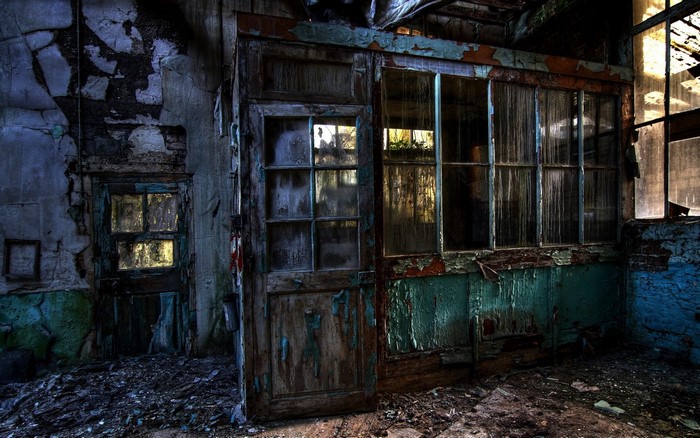 Abandoned building interior with broken doors and windows