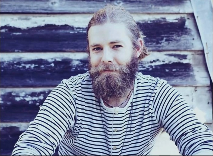 Man with beard and striped shirt