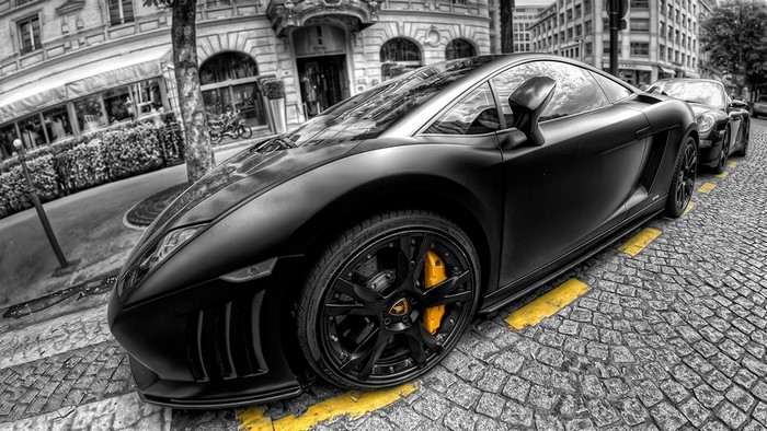 Black Lamborghini Gallardo parked on cobblestone street in Paris