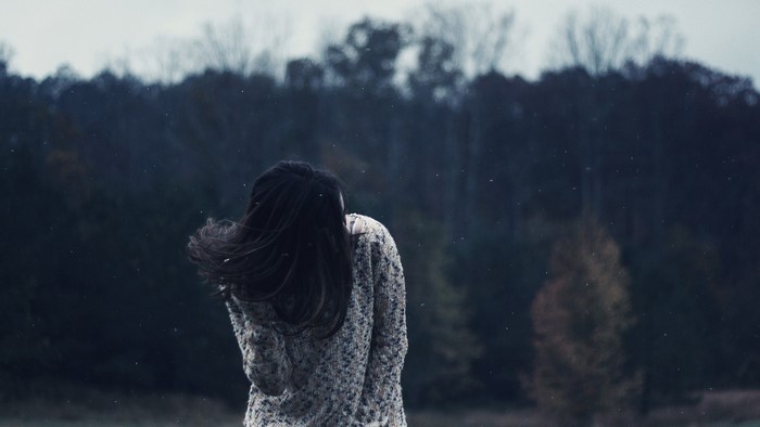 Woman in sweater in snowy forest