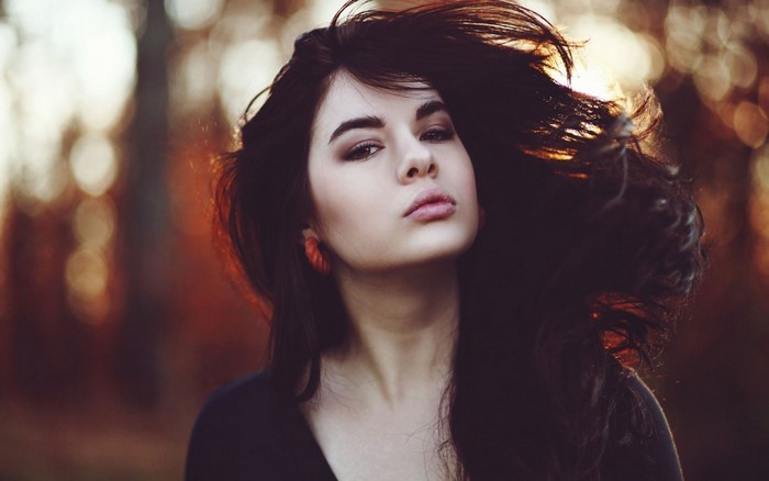 Woman with long dark hair and orange earrings