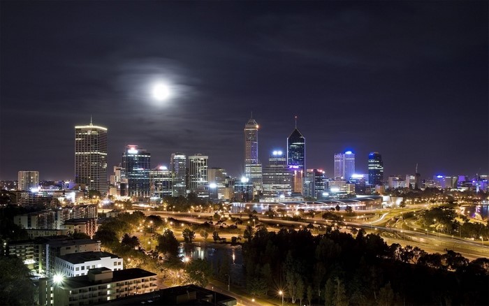 Cityscape skyline at night with moon